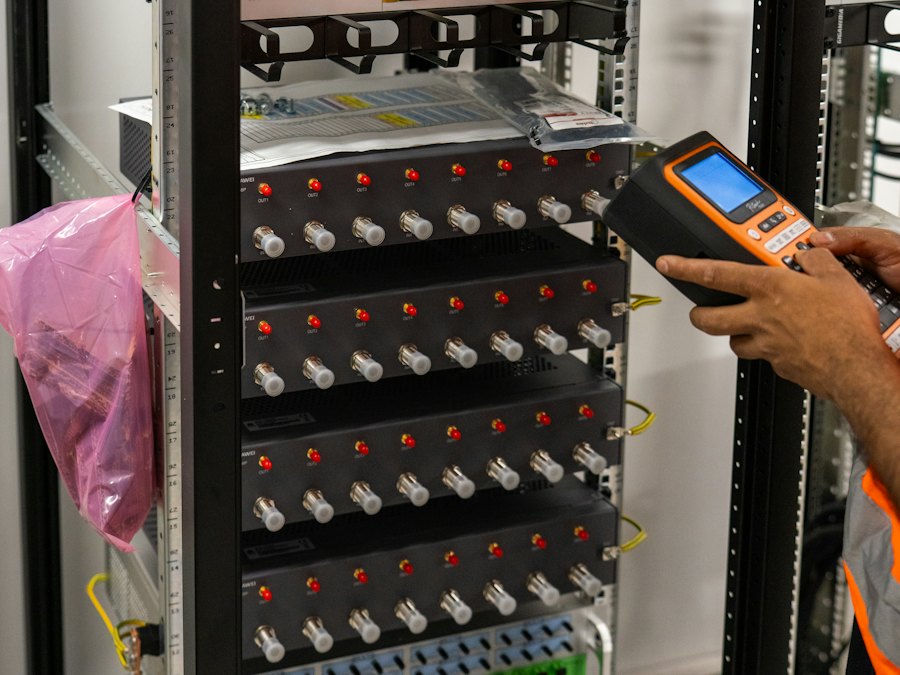 Technician testing connections at a network rack